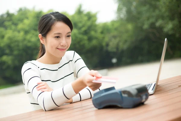 Jeune femme payant par carte de crédit — Photo