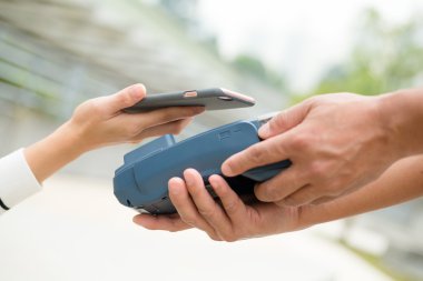 Fatura ödeme için cep telefonu kullanan kadın