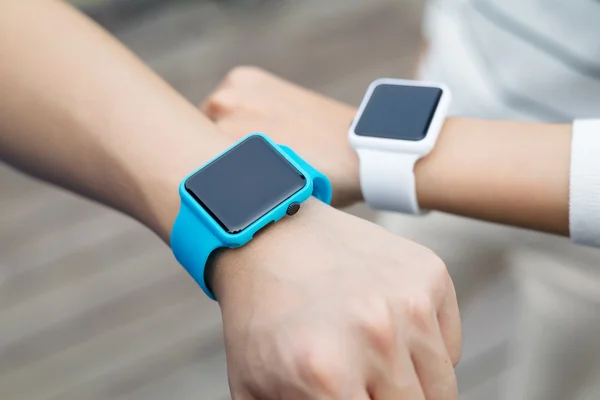 Couple comparing time on smart watches with each other — Stock Photo, Image