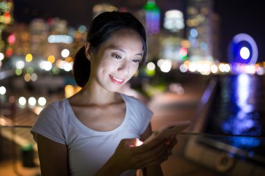 Geceleri cep telefonu kullanan kadın