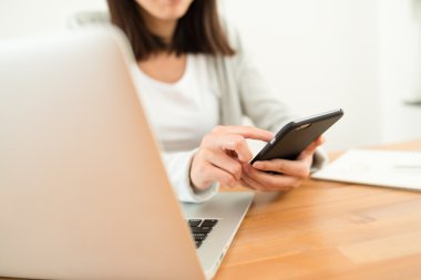 cep telefonu ve dizüstü bilgisayar kullanan kadın