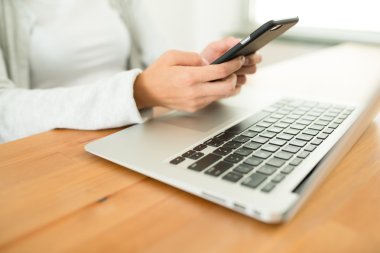 cep telefonu ve dizüstü bilgisayar kullanan kadın