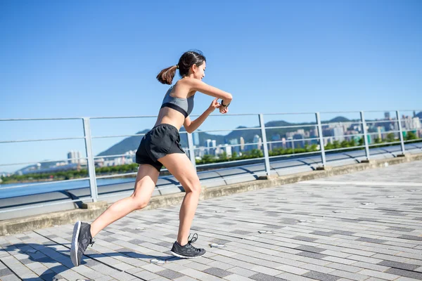 Woman running and using wearable watch — Stock Photo, Image