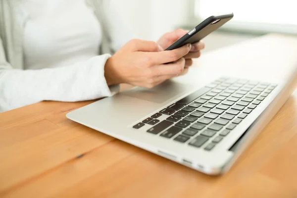 Mujer usando teléfono celular y computadora portátil — Foto de Stock