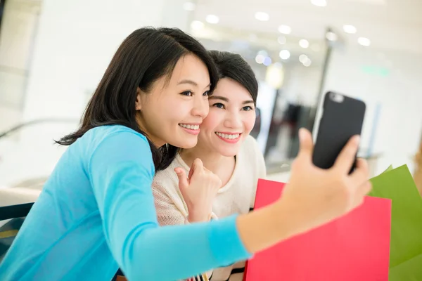 Vrouwen met boodschappentassen nemen foto — Stockfoto