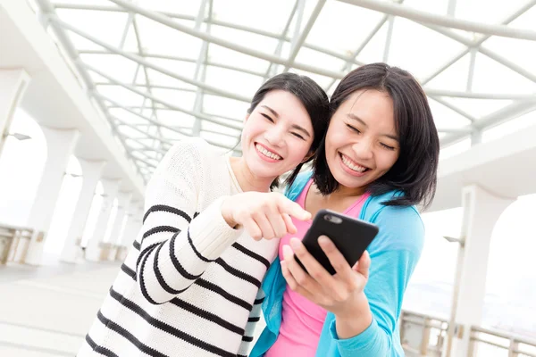 Frauen nutzen Handy gemeinsam im Freien — Stockfoto