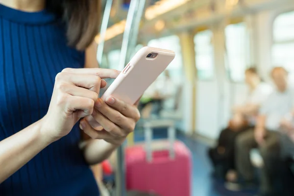 Woman using cellphone inside train — Stock Photo, Image