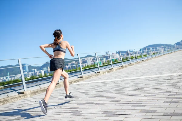 Kvinnan kör på seaside boardwalk — Stockfoto