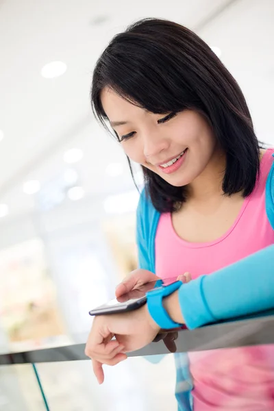 Vrouw slimme horloge en mobiele telefoon aansluiten — Stockfoto