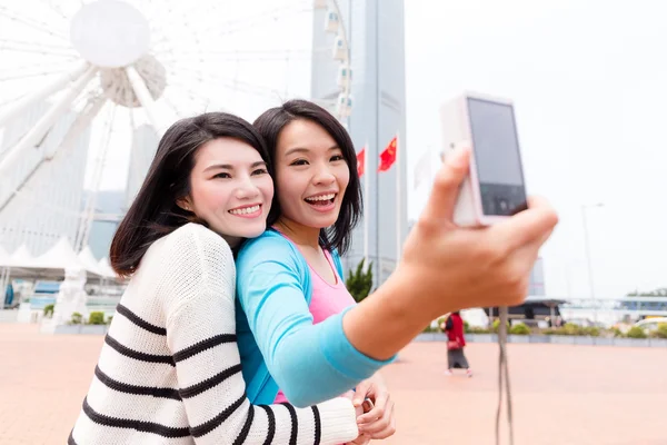 Women taking photo by camera together — Stock Photo, Image