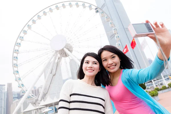 Women taking photo by camera together — Stock Photo, Image