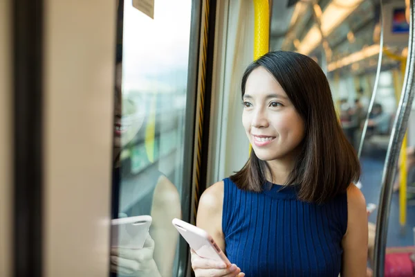 Mulher usando telefone celular no trem — Fotografia de Stock