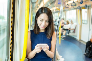 Mtr içinde cep telefonu kullanan kadın  