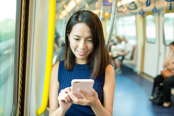 Woman using cellphone inside MTR — Stock Photo, Image