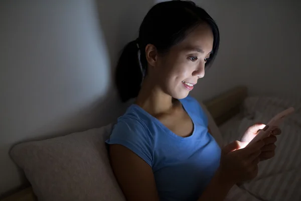 Kobieta korzystająca z telefonu komórkowego w nocy — Zdjęcie stockowe
