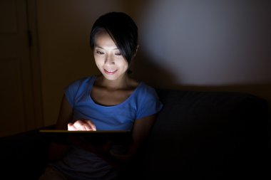 Geceleri tablet bilgisayar kullanan kadın