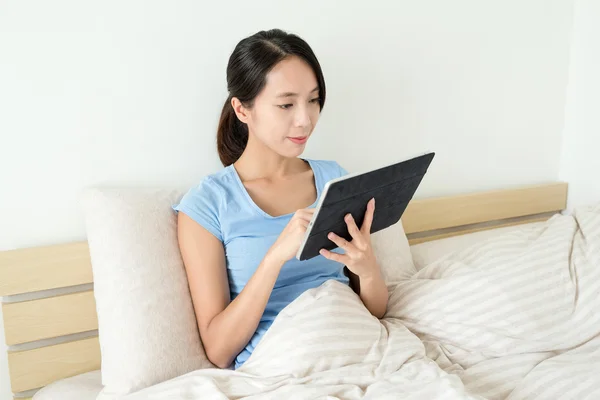 Vrouw met behulp van digitale tablet op bed — Stockfoto