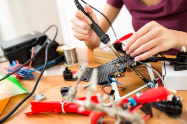 drone onarmak için kaynak kullanan kadın