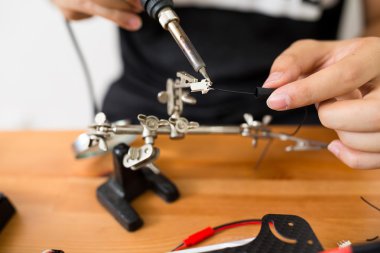 drone onarmak için kaynak kullanan adam