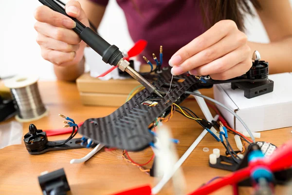 Mujer usando soldadura para reparar drones — Foto de Stock