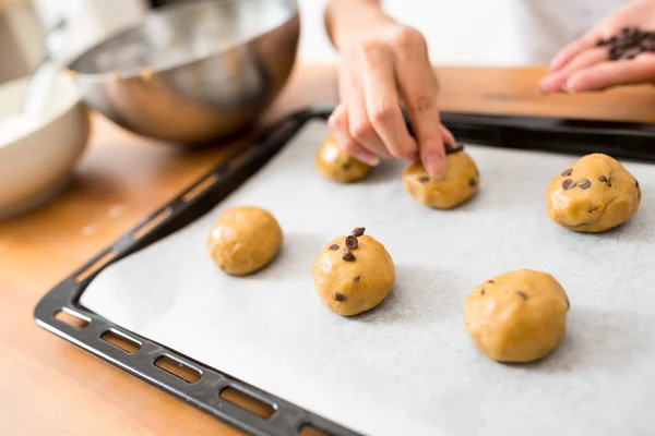 Kvinna att lägga choklad chip på degen — Stockfoto