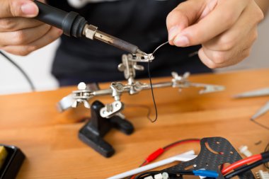 drone onarmak için kaynak kullanan adam