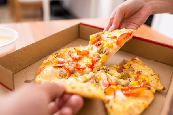 Vrouw nemen uit een plak van pizza — Stockfoto