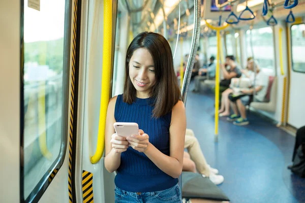 Woman using cellphone inside train — Stock Photo, Image