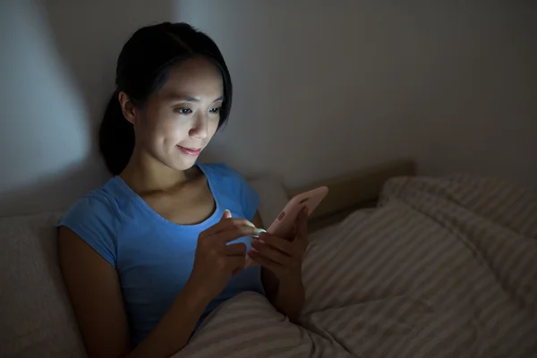 Vrouw die 's nachts een mobiele telefoon gebruikt — Stockfoto
