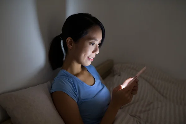 Frau benutzte Smartphone im Bett — Stockfoto