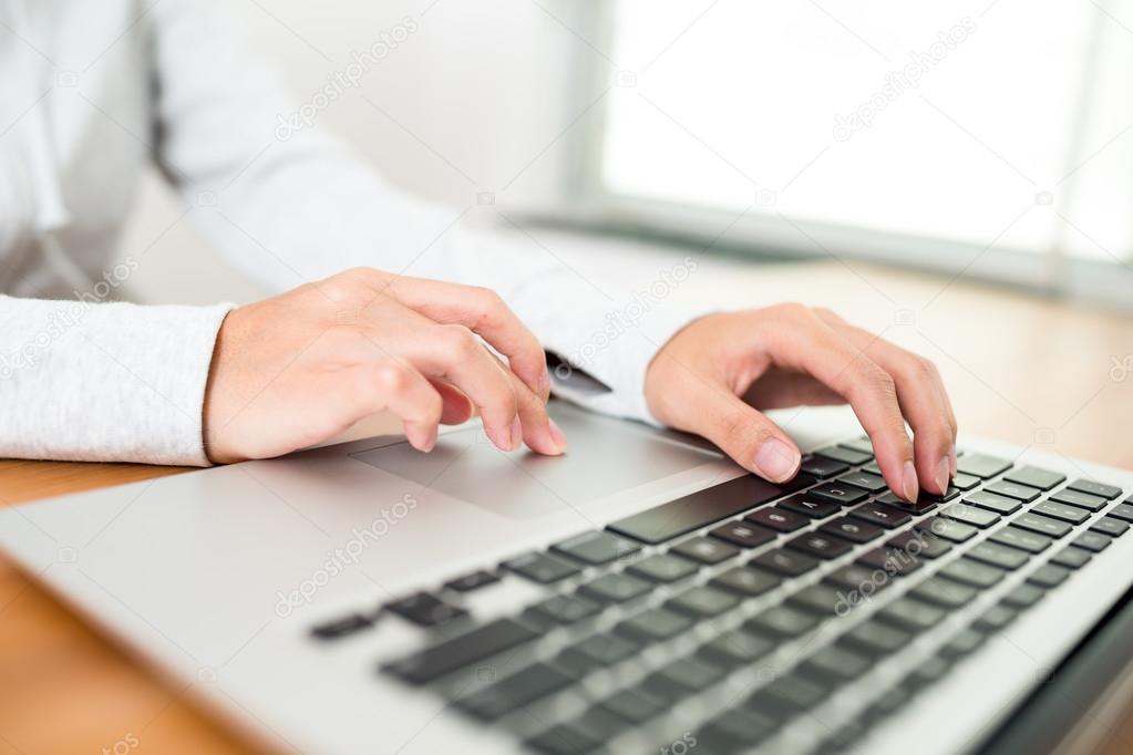 Woman typing on notebook computer