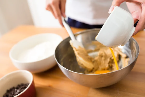 Adding chicken egg on dough — Stock Photo, Image