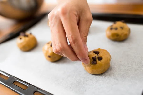 Frau fügt Schokolade auf die Kekse hinzu — Stockfoto