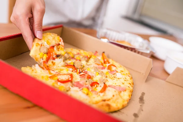 Vrouw nemen uit een plak van pizza — Stockfoto