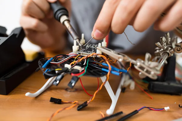 Uomo che utilizza la saldatura per riparare drone — Foto Stock