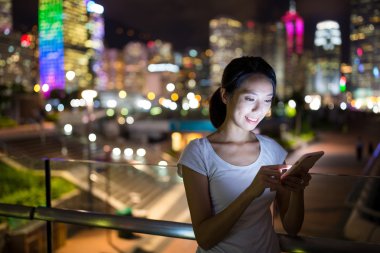 Geceleri cep telefonu kullanan kadın  