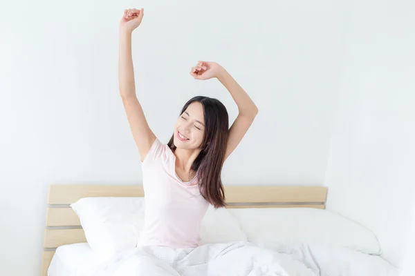 Woman stretching hands in bed — Stock Photo, Image