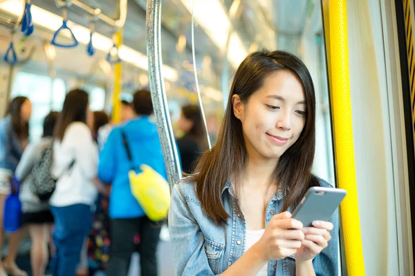 Женщина с помощью мобильного телефона внутри поезда — стоковое фото