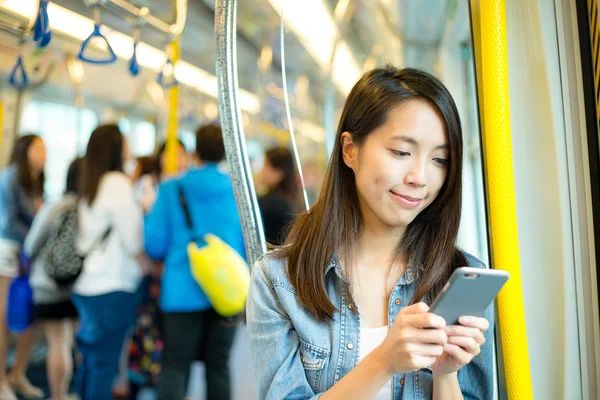 Woman using cellphone inside train — Stock Photo, Image