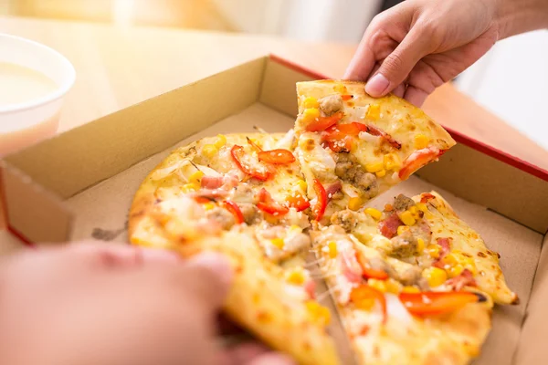Vrouw nemen uit een plak van pizza — Stockfoto