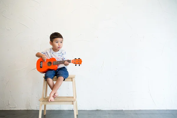 Little boy playing with ukulele — Stock Photo, Image