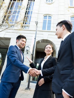 Yeni ortağı ile tokalaşırken işadamı