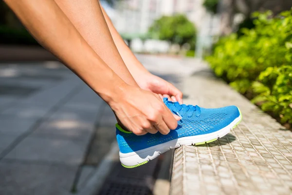 Mujer tratando de cordón de zapatos — Foto de Stock