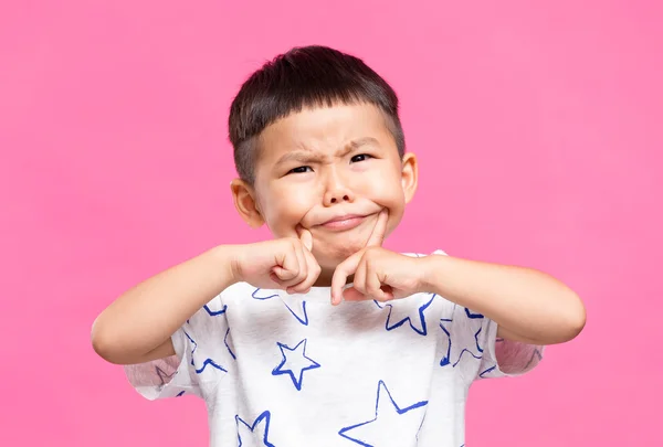 Malý chlapec uvedení prsty na tvářích — Stock fotografie