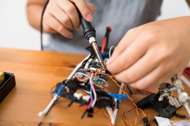 drone onarmak için kaynak kullanan adam