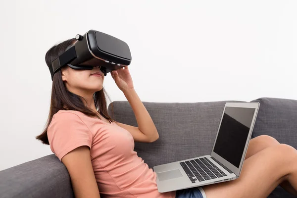 Mujer mirando a través de la realidad virtual con ordenador portátil —  Fotos de Stock