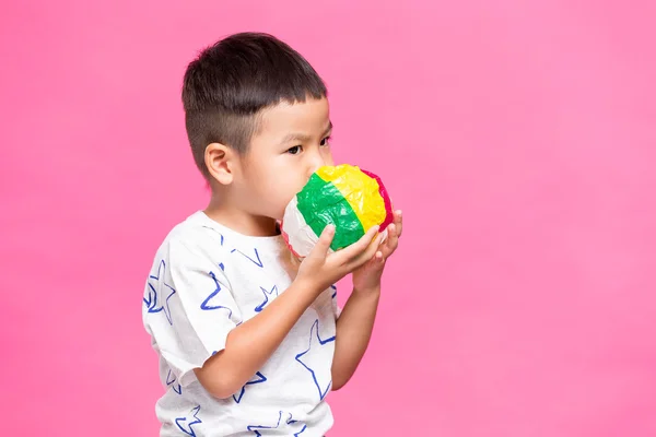 Kid blåser med papper boll — Stockfoto