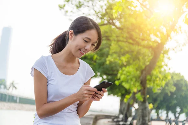 Mulher usando celular no parque — Fotografia de Stock