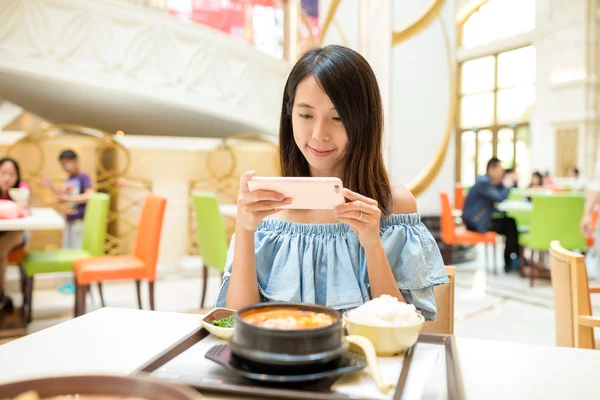 Женщина фотографирует на мобильный телефон перед едой — стоковое фото