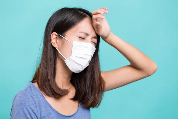 Wanita mengenakan masker wajah dan menderita sakit kepala — Stok Foto